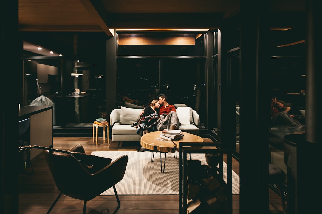 A welcoming and luxurious ski chalet living room with a fireplace, where a tablet displaying a welcome screen sits on a wooden coffee table, ready for the guest.