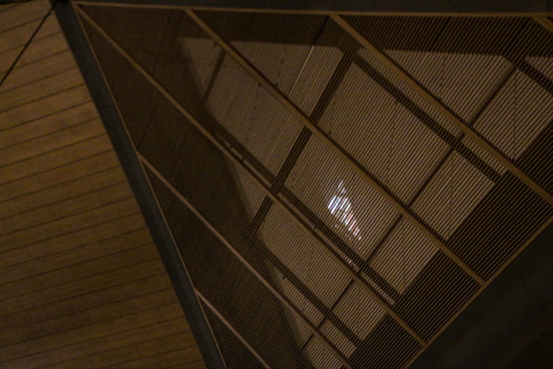 A close-up architectural detail of a high-end home, showing the precise joinery of wood beams, stone walls, and glass, representing quality construction.